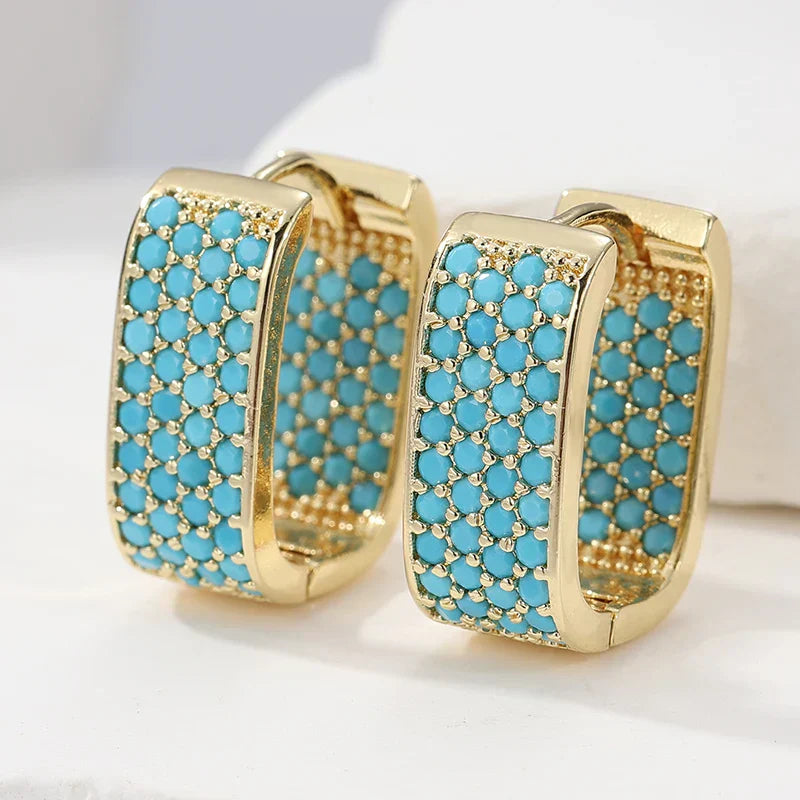 Orecchini huggie dorati con pavé turchese