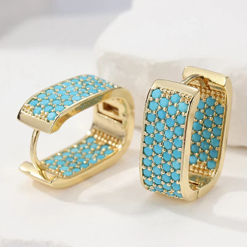 Orecchini huggie dorati con pavé turchese
