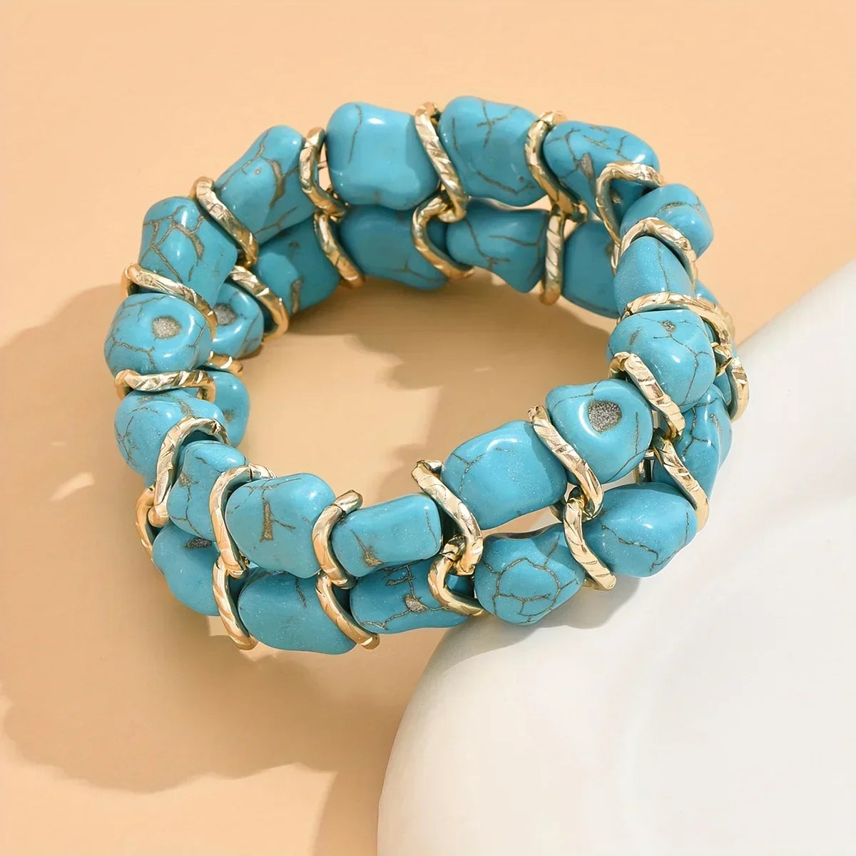Bracciale intrecciato dorato con pietra turchese